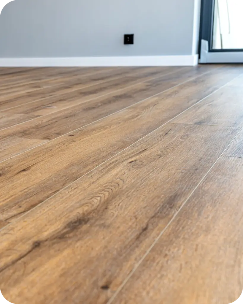 Detailaufnahme eines frisch verlegten Vinylbodens in natürlicher Holzoptik in einem modernen Wohnraum