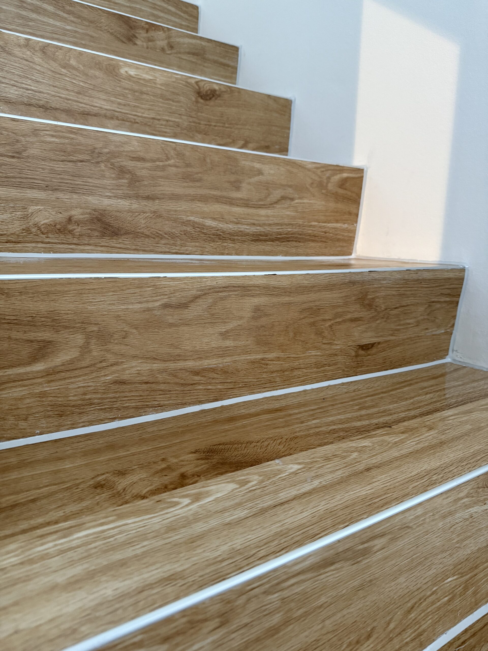 Nahaufnahme von Vinyl-Trittstufen und Setzstufen in Holzoptik mit schmalen silberfarbenen Kantenprofilen