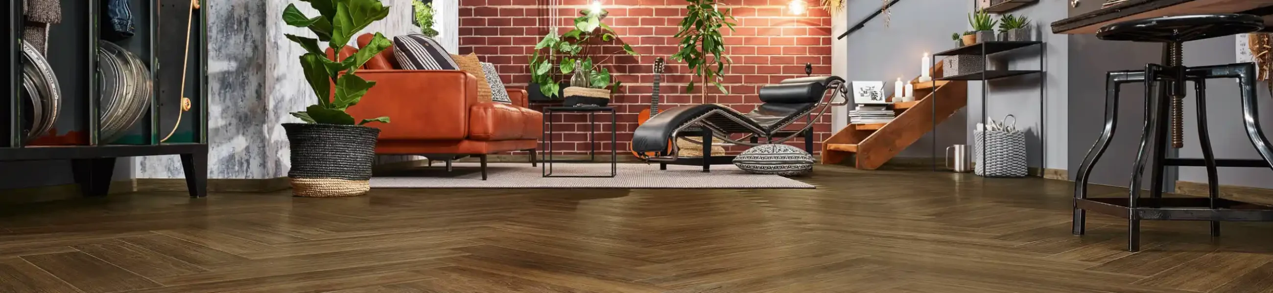 Modern eingerichteter Wohnraum mit hochwertigem Fischgrät-Designboden in dunkler Holzoptik – Perfekt für ein stilvolles Industrial-Design.